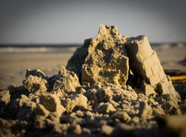 A,sand,castle,on,a,beach,that,has,collapsed