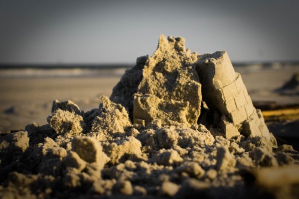 A,sand,castle,on,a,beach,that,has,collapsed