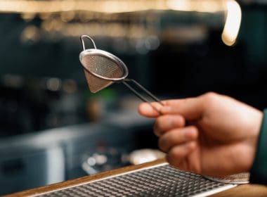 Bartender's,tool,for,making,cocktails,bartender,holds,strainer,in,his