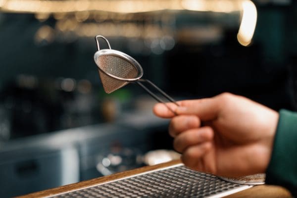 Bartender's,tool,for,making,cocktails,bartender,holds,strainer,in,his