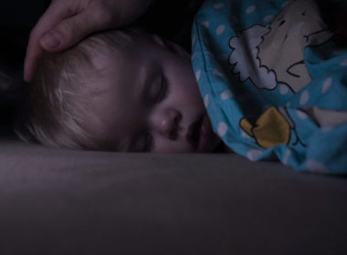 Little,baby,boy,sweetly,sleeps,in,bed,,dad,puts,his