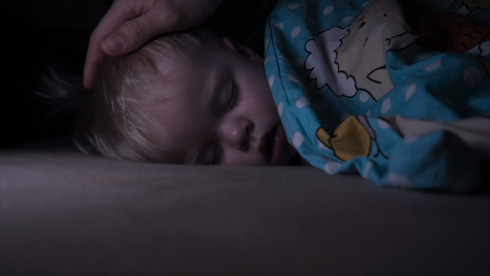 Little,baby,boy,sweetly,sleeps,in,bed,,dad,puts,his