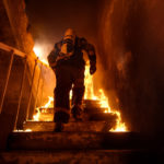 Strong,and,brave,firefighter,going,up,the,stairs,in,burning