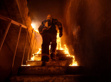 Strong,and,brave,firefighter,going,up,the,stairs,in,burning