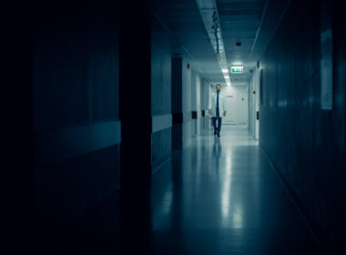 Medical,doctor,walks,into,dark,part,of,the,hospital,corridor