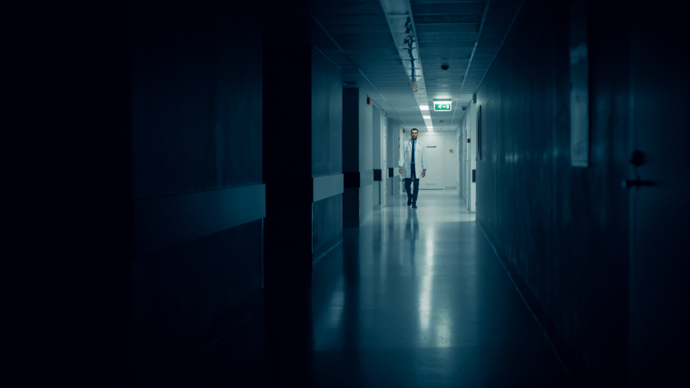 Medical,doctor,walks,into,dark,part,of,the,hospital,corridor