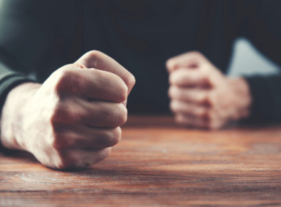 Man,fists,on,a,wooden,table