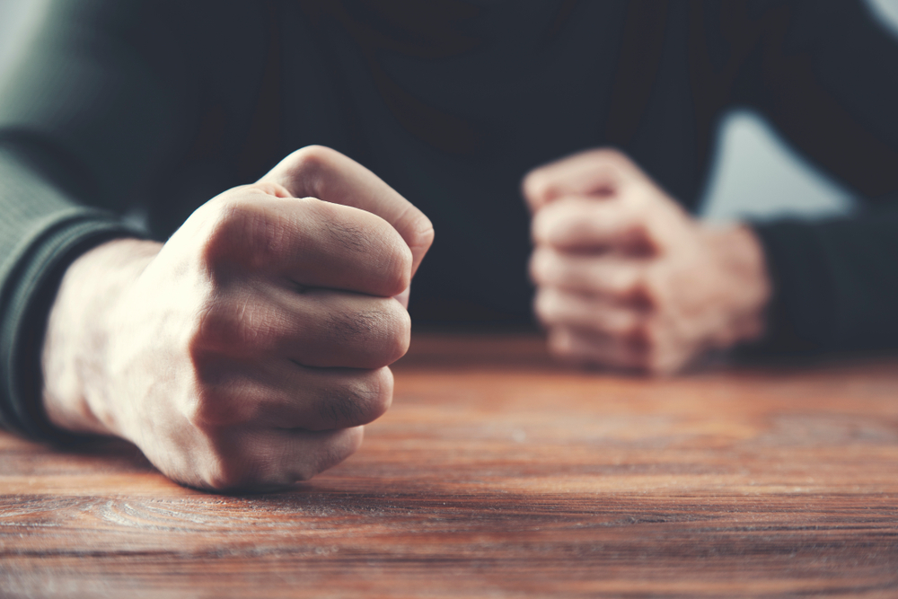 Man,fists,on,a,wooden,table