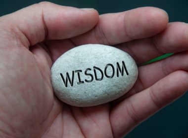 Wisdom,text,engraved,on,zen,stones,with,hand,background ,wisdom