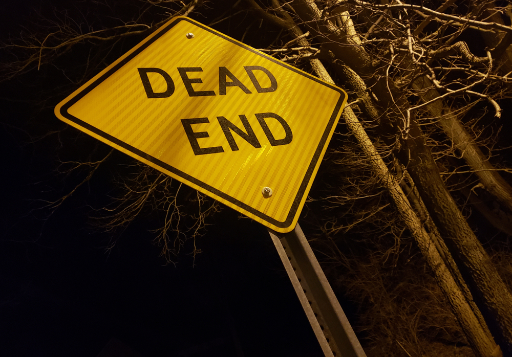 Angled,dead,end,sign,at,night,with,creepy,trees,and