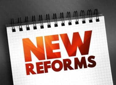 New,reforms,text,quote,on,notepad,,concept,background