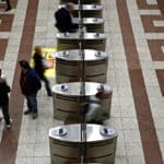 People,walk,between,subway,ticket,validation,machines,on,platform,of