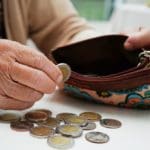 Retired,elderly,woman,counting,coins,money,and,worry,about,monthly