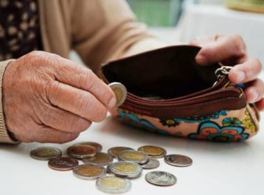 Retired,elderly,woman,counting,coins,money,and,worry,about,monthly