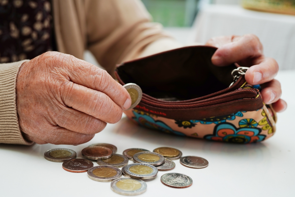 Retired,elderly,woman,counting,coins,money,and,worry,about,monthly