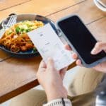 Closeup,woman,is,holding,a,food,receipt,and,smart,phone