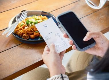 Closeup,woman,is,holding,a,food,receipt,and,smart,phone