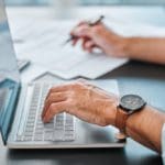 Desk,,laptop,and,hands,with,paperwork,in,office,for,bookkeeping,