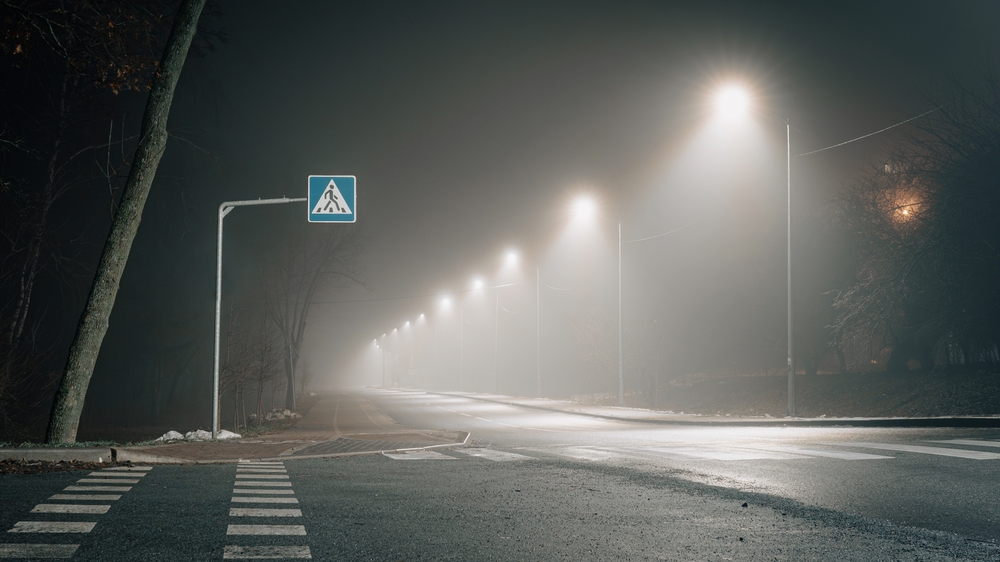Foggy,night,scene,with,an,illuminated,pedestrian,crossing,and,a