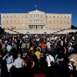 People,chant,slogans,in,front,of,the,greek,parliament,in
