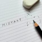 Close,up,of,pencil,eraser,correcting,word,mistakes,on,white