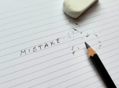 Close,up,of,pencil,eraser,correcting,word,mistakes,on,white