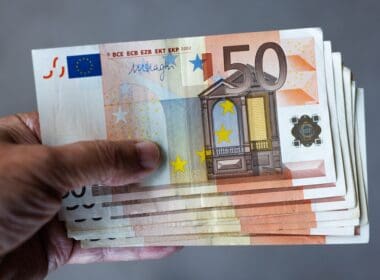 A,man,holds,a,stack,of,50,euro,banknotes,in