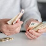 Elderly,woman's,hands,count,money,,euros,,in,close up,view