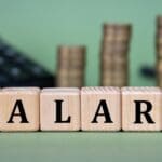 Salary, ,word,on,wooden,cubes,with,calculator,and,coins