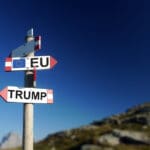 Trump,and,european,flag,in,two,directions,on,road,sign
