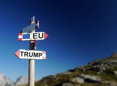 Trump,and,european,flag,in,two,directions,on,road,sign