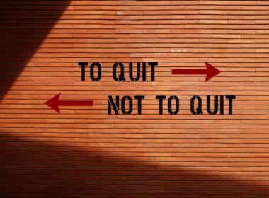 Brick,wall,background,with,inscription,opposite,direction,signs,to,quit