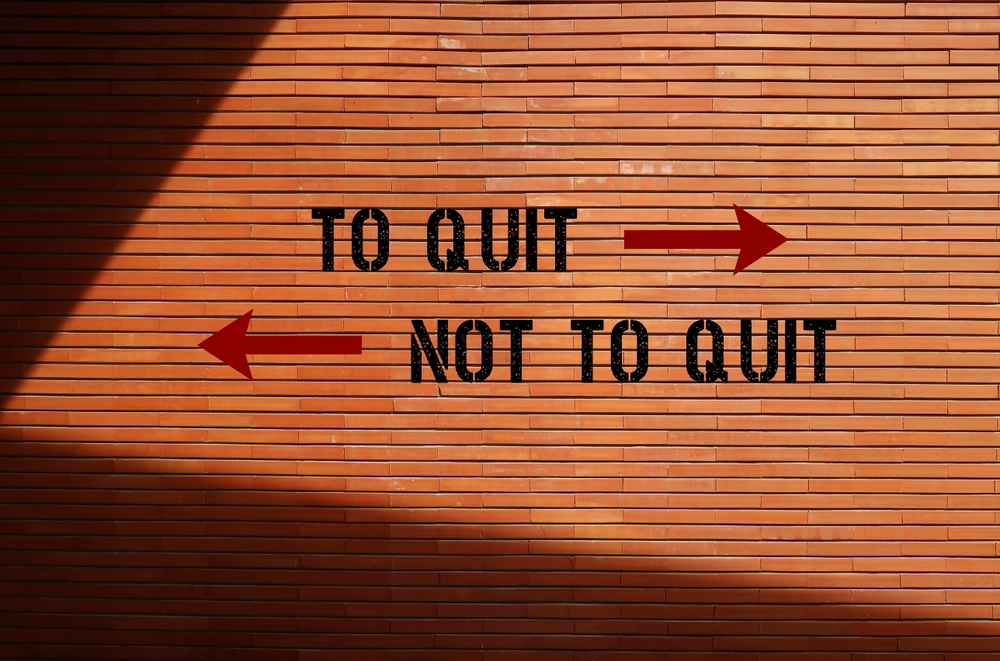 Brick,wall,background,with,inscription,opposite,direction,signs,to,quit