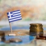 Greek,flag,with,coins,on,a,map,representing,the,economy,