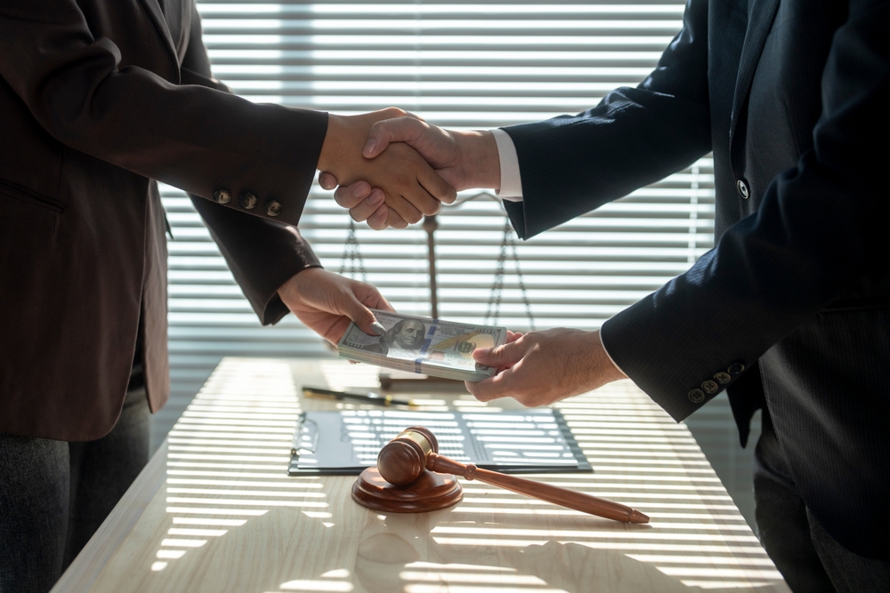 Corrupt,lawyers,shaking,hands,while,exchanging,bribe,money,after,making