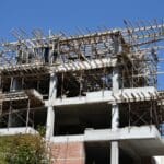 Building,under,construction,at,early,stages,,with,blue,sky,background