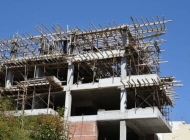 Building,under,construction,at,early,stages,,with,blue,sky,background
