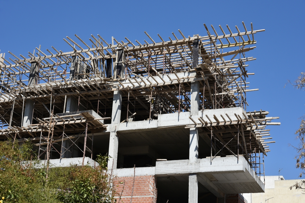 Building,under,construction,at,early,stages,,with,blue,sky,background