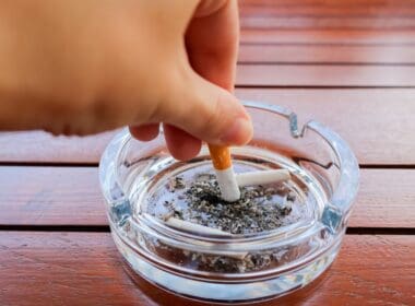 Hand,putting,out,cigarette,in,ashtray ,glass,ashtray,with,cigarette