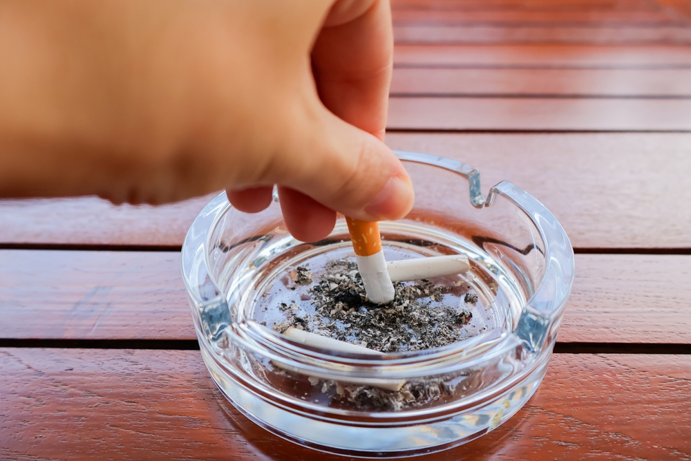 Hand,putting,out,cigarette,in,ashtray ,glass,ashtray,with,cigarette