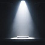 A,single,spotlight,illuminates,an,empty,table,on,a,dark