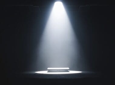 A,single,spotlight,illuminates,an,empty,table,on,a,dark