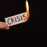 Burning,a,piece,of,paper,with,the,word,"crisis",written
