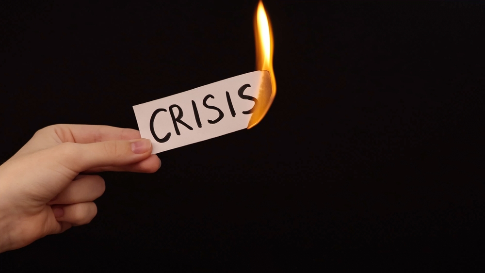 Burning,a,piece,of,paper,with,the,word,"crisis",written
