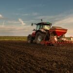 Farmer,with,tractor,seeding, ,sowing,crops,at,agricultural,field