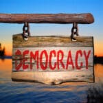 Democracy,motivational,phrase,sign,on,old,wood,with,blurred,background