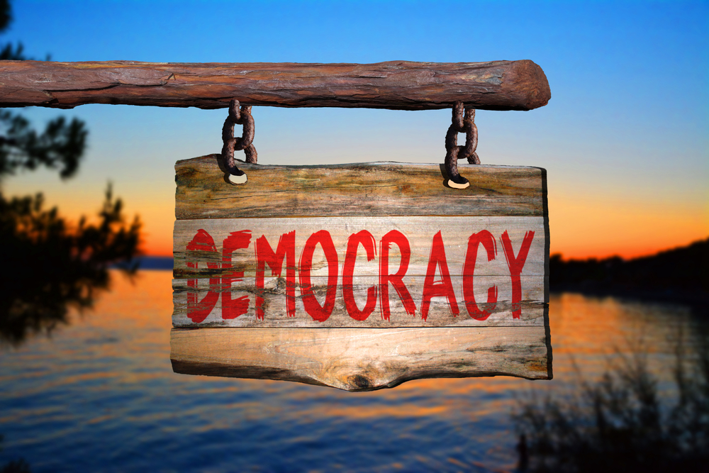 Democracy,motivational,phrase,sign,on,old,wood,with,blurred,background