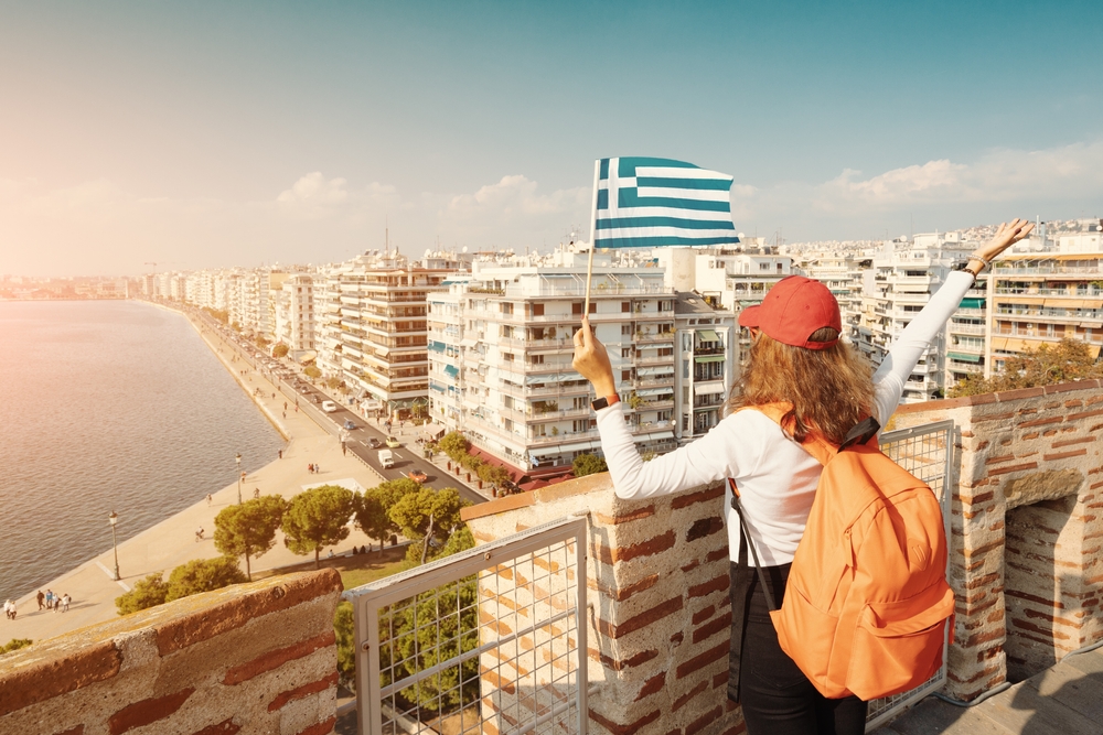 Happy,student,traveller,girl,with,a,greek,flag,on,the