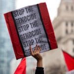 Person,holds,up,a,sign,saying,stop,the,genocide,at