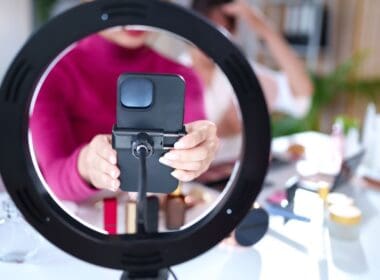 Asian,young,woman,hands,hold,phone,setup,with,ring,light